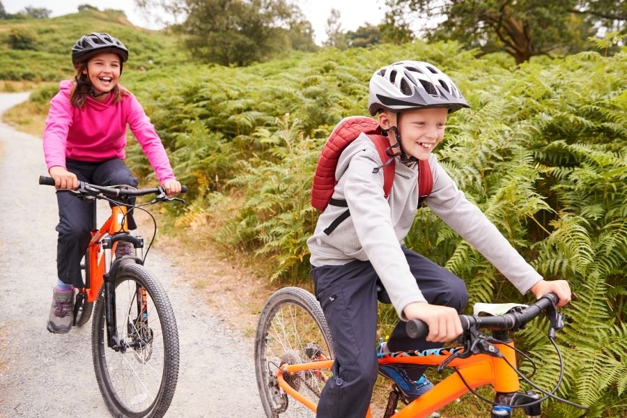 niño y niña montando en bici