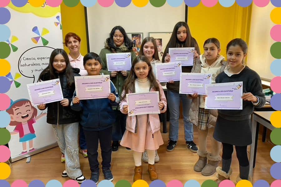 fotografía de ocho niños y una monitora, mostrando diplomas de color violeta